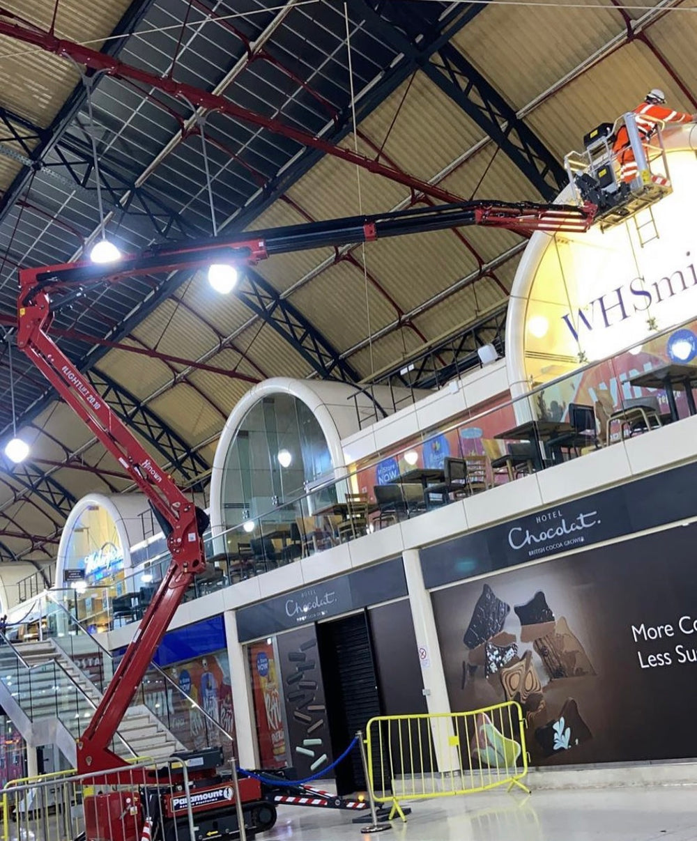 Powered access equipment being used for high level commercial cleaning inside a large public building